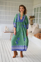 Model wearing Bluebird Boheme Midi Dress by Jaase - boho floral print, long sleeves, soft rayon fabric, relaxed flowy silhouette.
