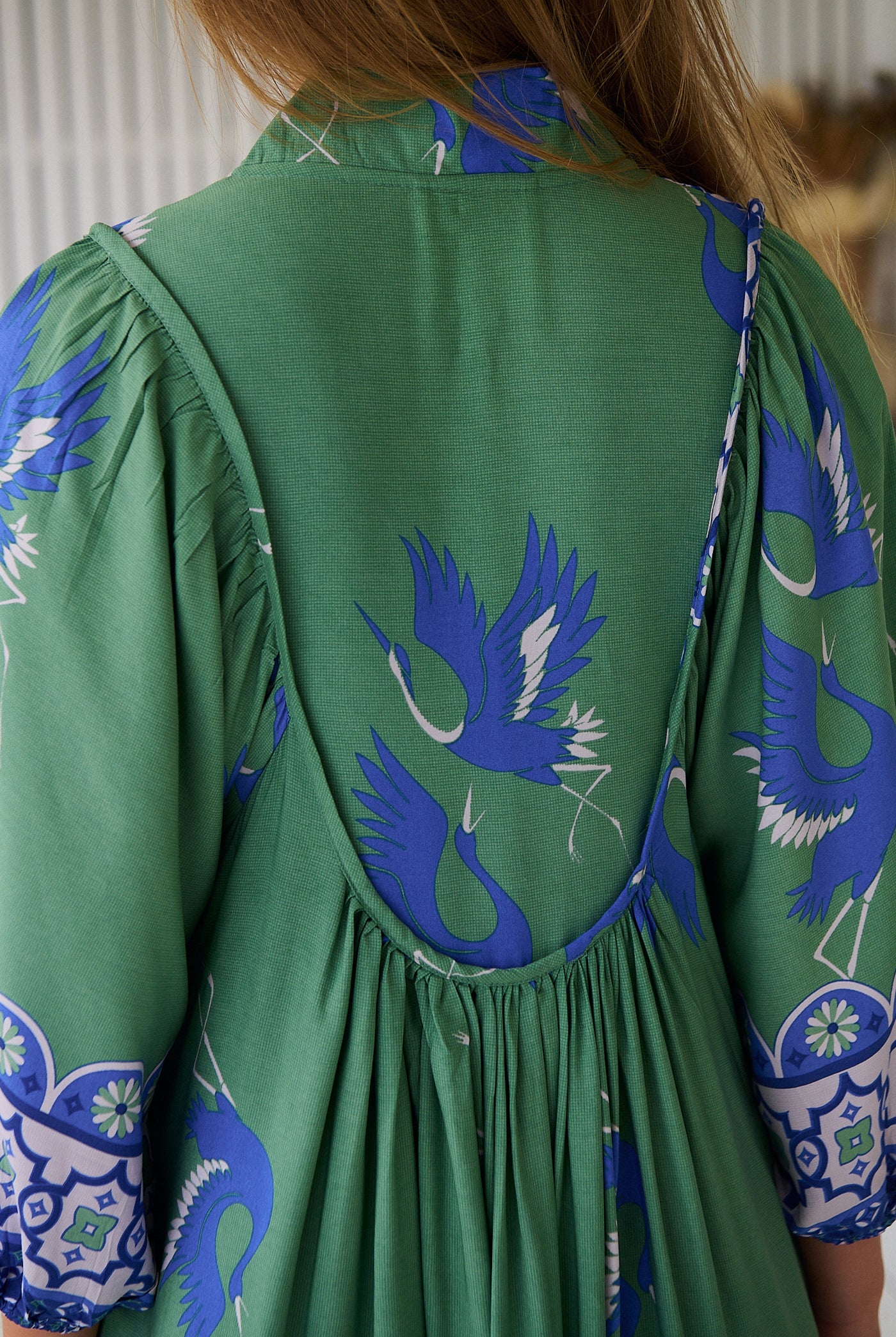 Model wearing Bluebird Boheme Midi Dress by Jaase - boho floral print, long sleeves, soft rayon fabric, relaxed flowy silhouette.