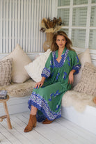 Model wearing Bluebird Boheme Midi Dress by Jaase - boho floral print, long sleeves, soft rayon fabric, relaxed flowy silhouette.