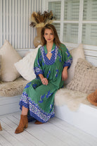 Model wearing Bluebird Boheme Midi Dress by Jaase - boho floral print, long sleeves, soft rayon fabric, relaxed flowy silhouette.