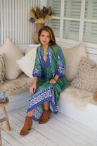 Model wearing Bluebird Boheme Midi Dress by Jaase - boho floral print, long sleeves, soft rayon fabric, relaxed flowy silhouette.