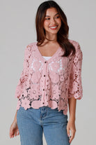 Woman in dusty rose pink floral crochet cardigan with scalloped hem - romantic boho knitwear Australia.
