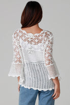 Woman wearing white cotton crochet top with scalloped hem and wide sleeves - Boho crochet blouse Australia.