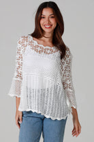 Woman wearing white cotton crochet top with scalloped hem and wide sleeves - Boho crochet blouse Australia.