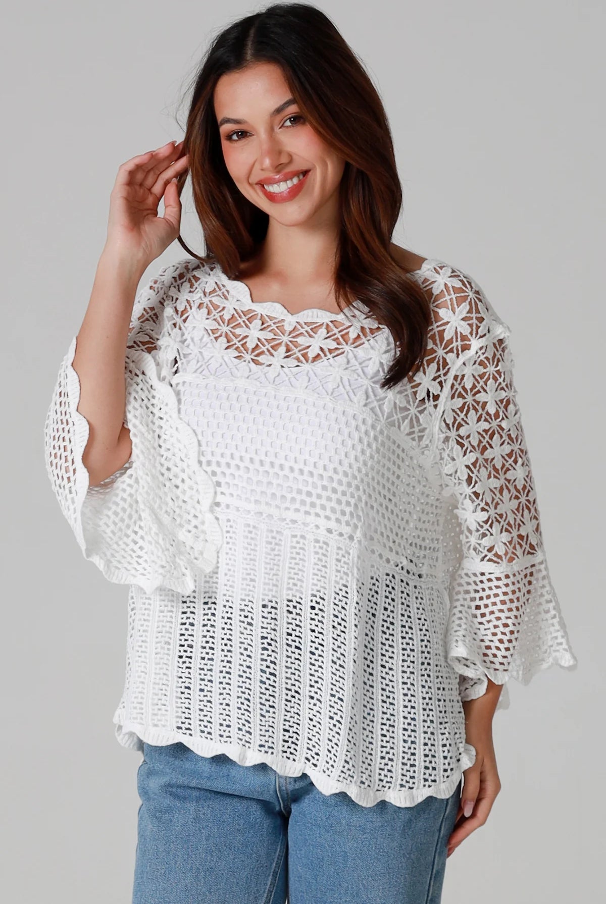 Woman wearing white cotton crochet top with scalloped hem and wide sleeves - Boho crochet blouse Australia.