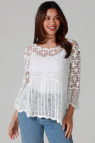 Woman wearing white cotton crochet top with scalloped hem and wide sleeves - Boho crochet blouse Australia.
