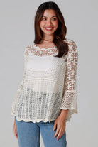 Woman wearing cream cotton crochet top with scalloped neckline and bell sleeves - Boho crochet blouse Australia.