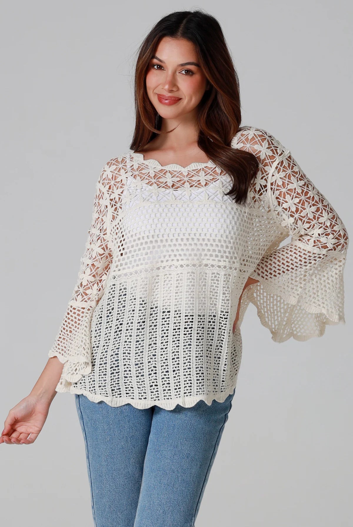 Woman wearing cream cotton crochet top with scalloped neckline and bell sleeves - Boho crochet blouse Australia.