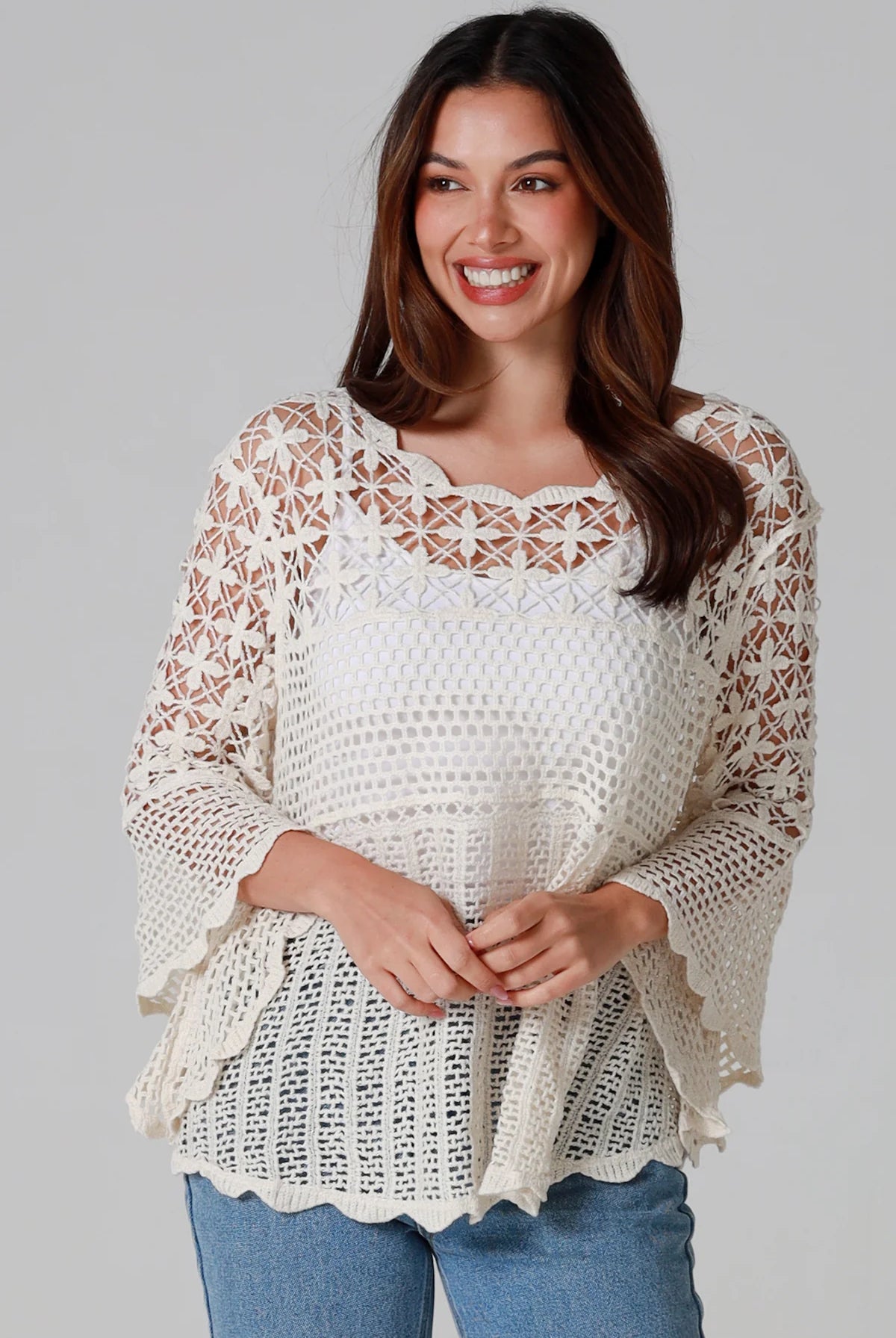 Woman wearing cream cotton crochet top with scalloped neckline and bell sleeves - Boho crochet blouse Australia.