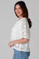 Woman wearing white cotton crochet cardigan with collar and buttons - boho knit top Australia.