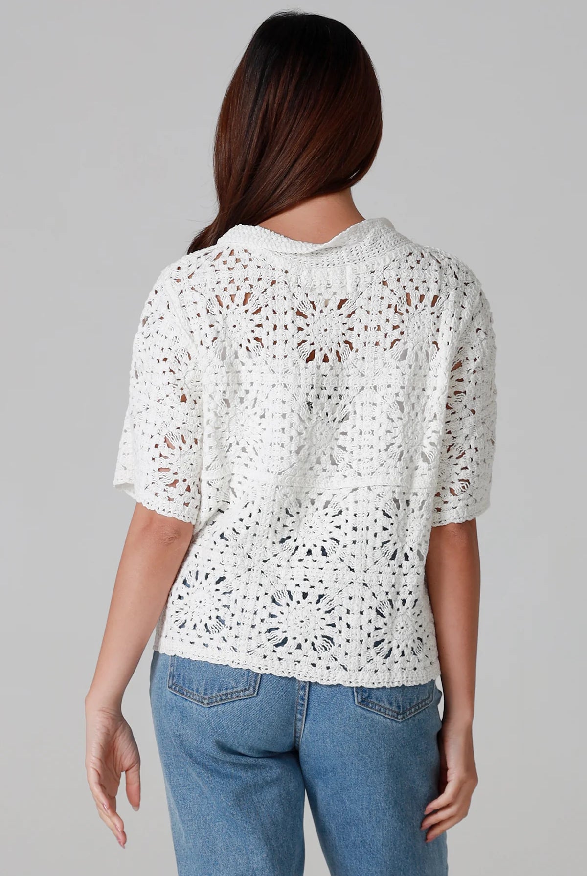 Woman wearing white cotton crochet cardigan with collar and buttons - boho knit top Australia.