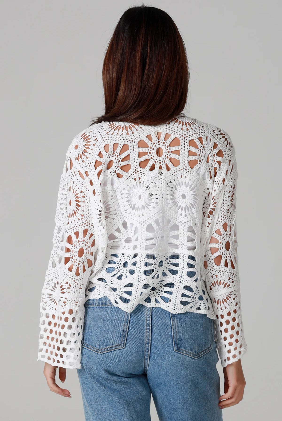 White crochet cardigan with tie front and boho bell sleeves layered over denim - crochet cardigan Australia.