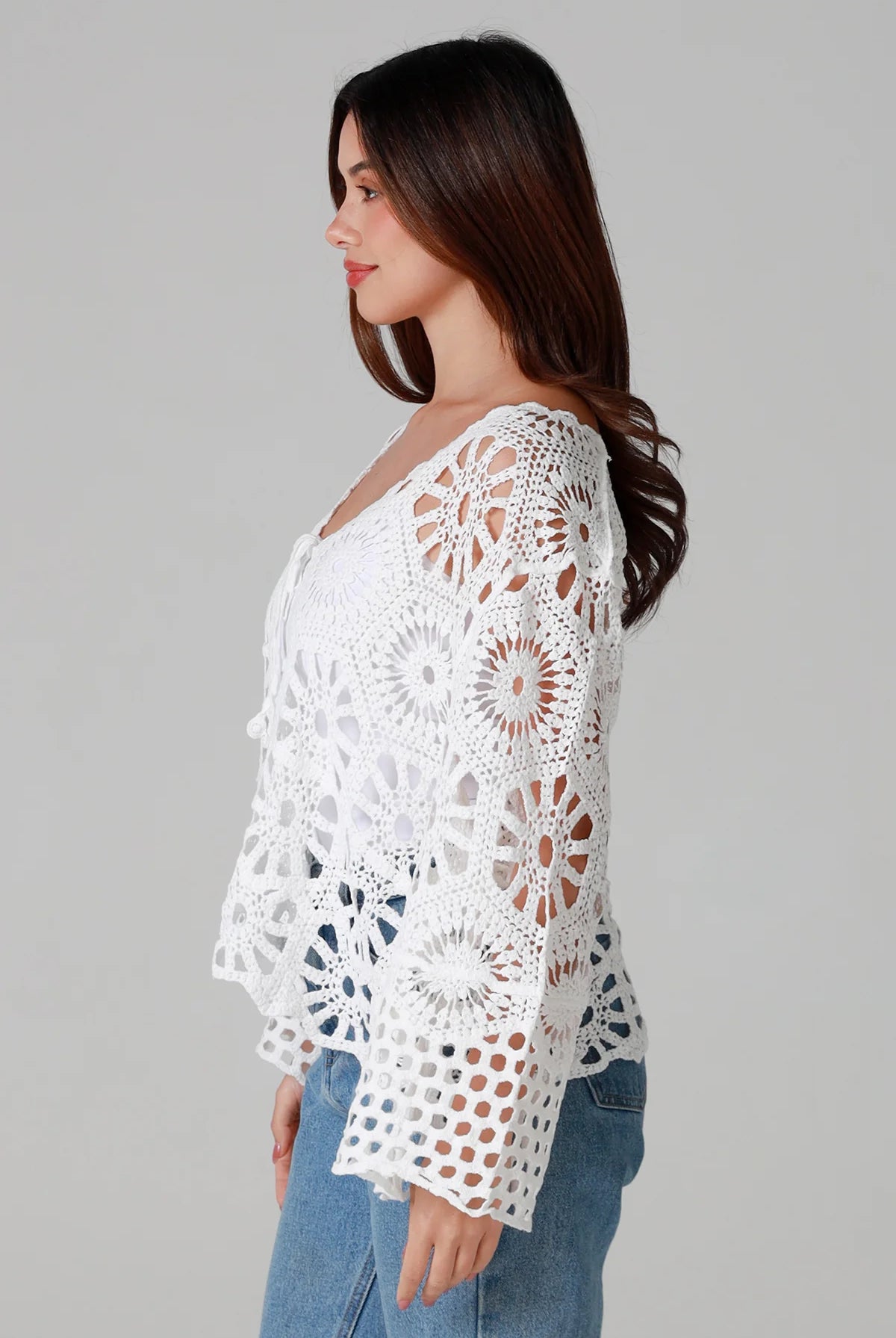 White crochet cardigan with tie front and boho bell sleeves layered over denim - crochet cardigan Australia.