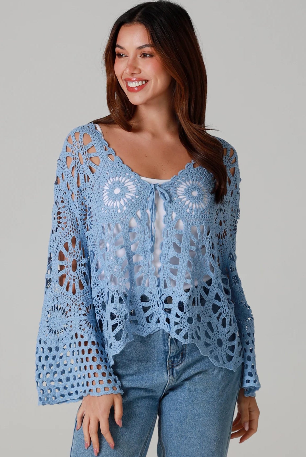 Pale blue cotton crochet boho cardigan with bell sleeves and tie front styled with denim - bohemian coastal fashion.