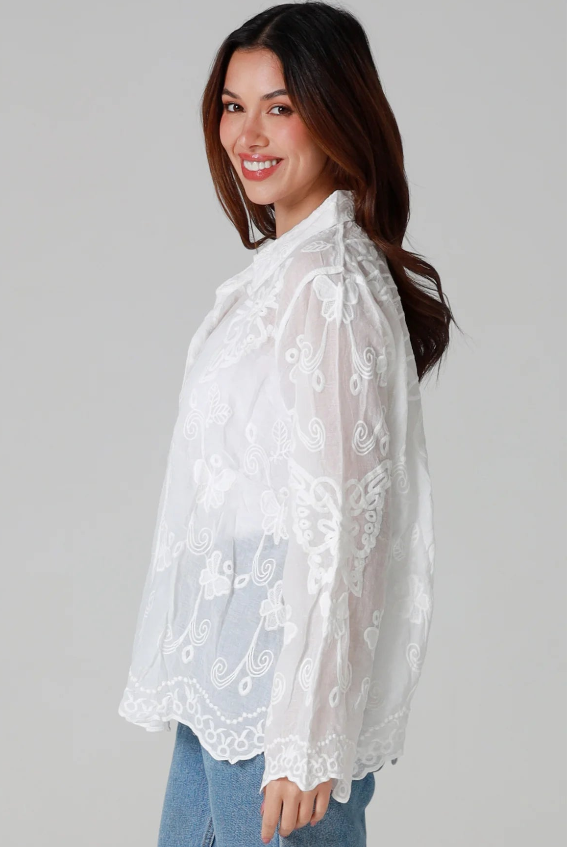 Woman in white cotton embroidered butterfly shirt with scalloped cuffs - boho blouse Australia.