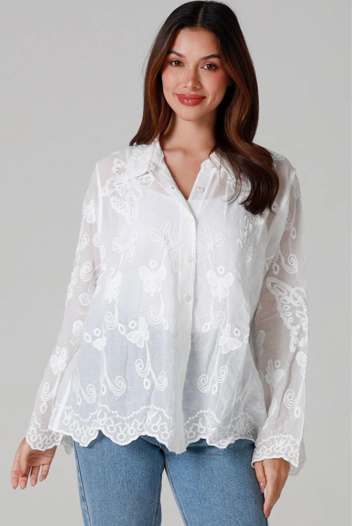 Woman in white cotton embroidered butterfly shirt with scalloped cuffs - boho blouse Australia.