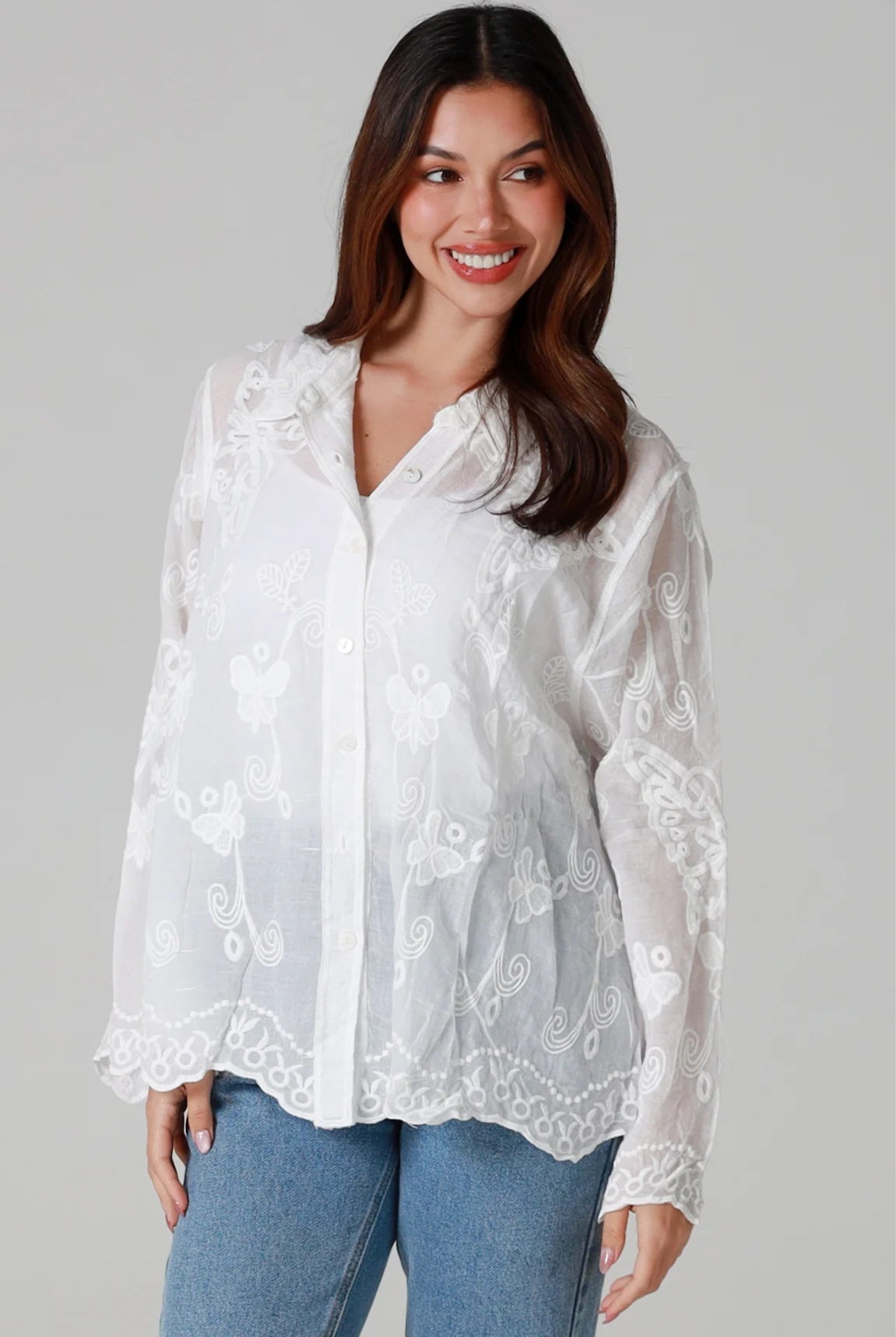 Woman in white cotton embroidered butterfly shirt with scalloped cuffs - boho blouse Australia.