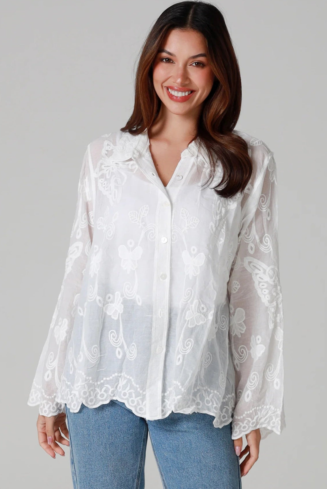 Woman in white cotton embroidered butterfly shirt with scalloped cuffs - boho blouse Australia.