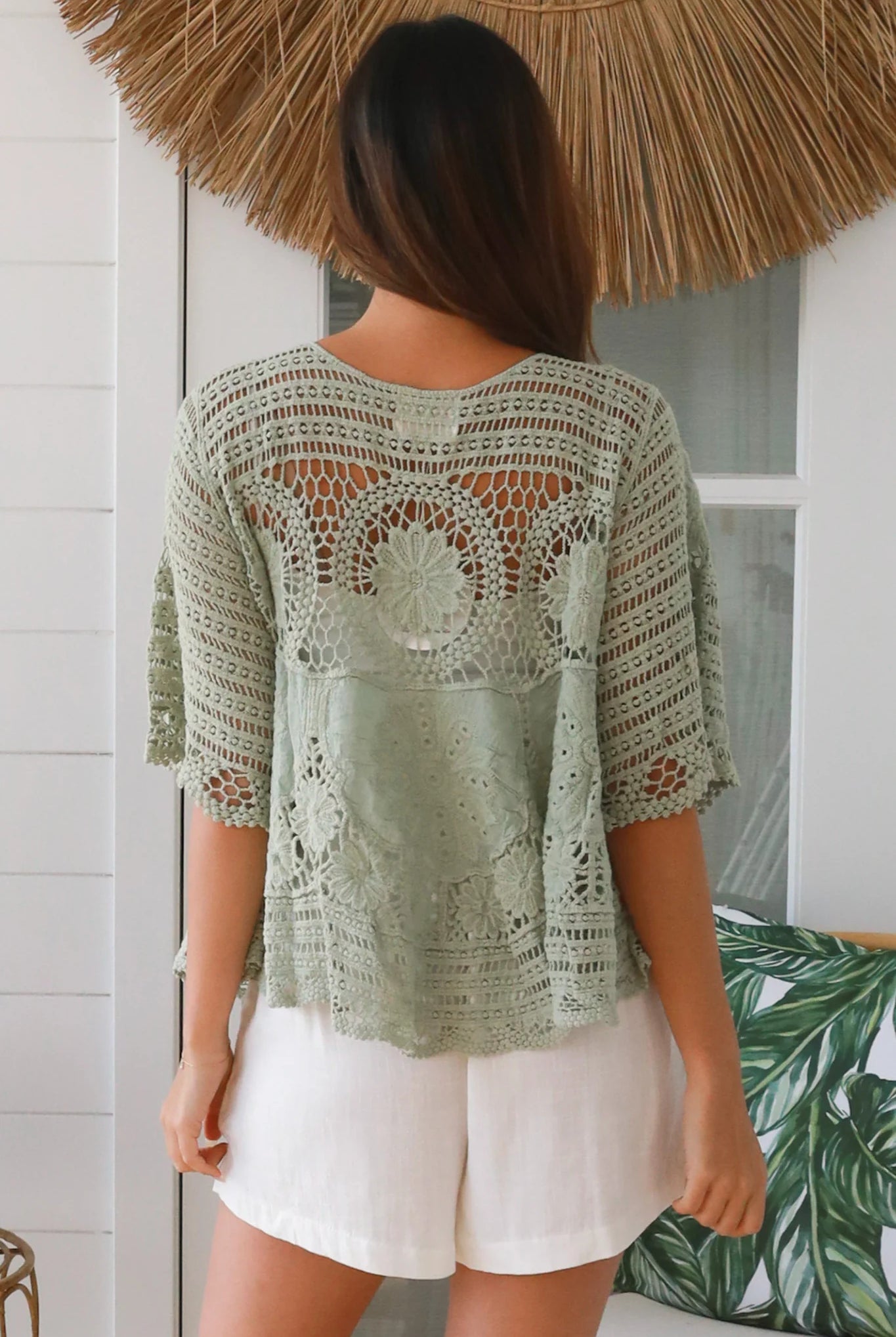 Woman in sage green cotton crochet top with embroidered floral lace and tassel ties - Olivia boho top Australia.