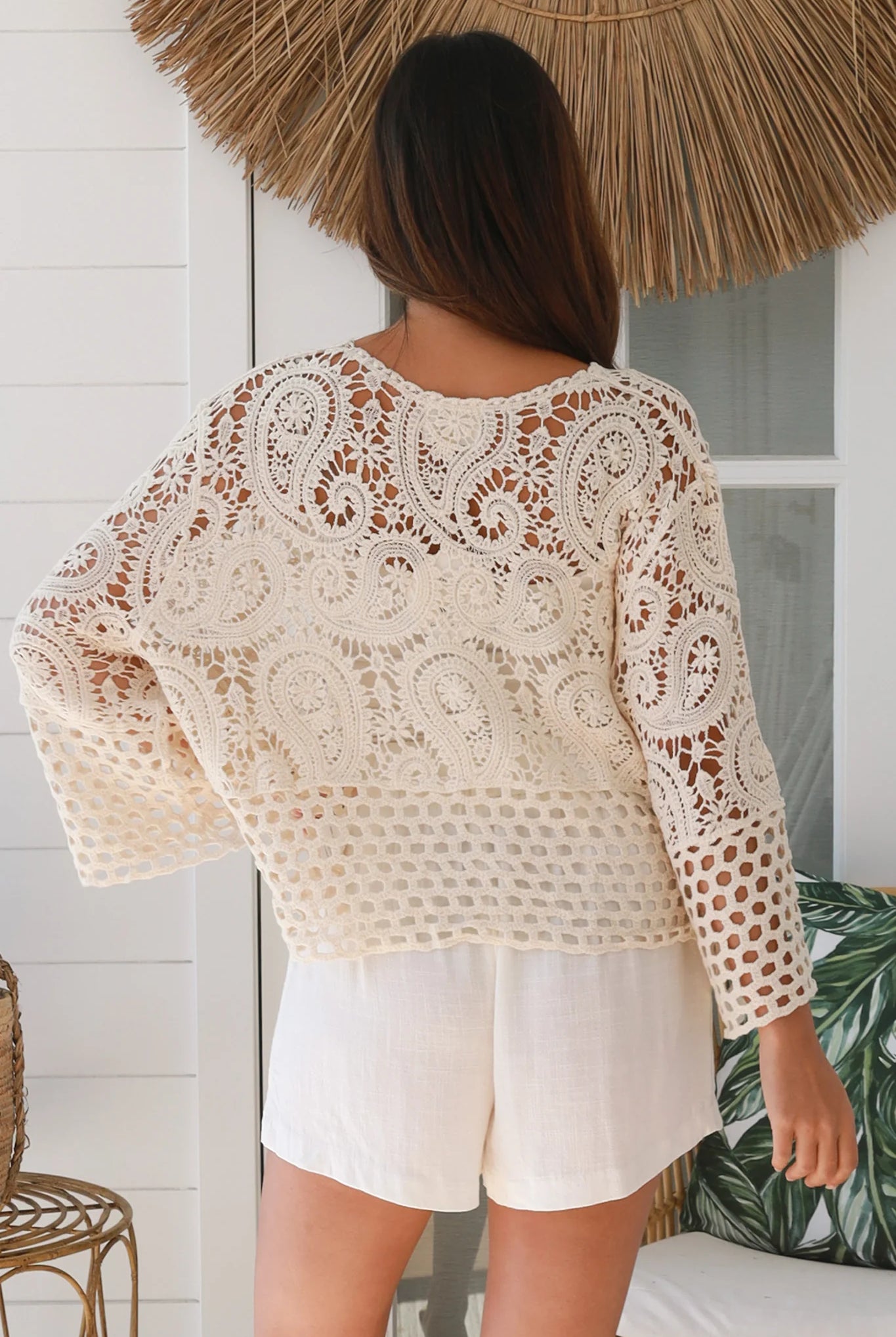 Woman wearing a cream crochet cotton jacket with bell sleeves and tie-front - boho layering piece Australia