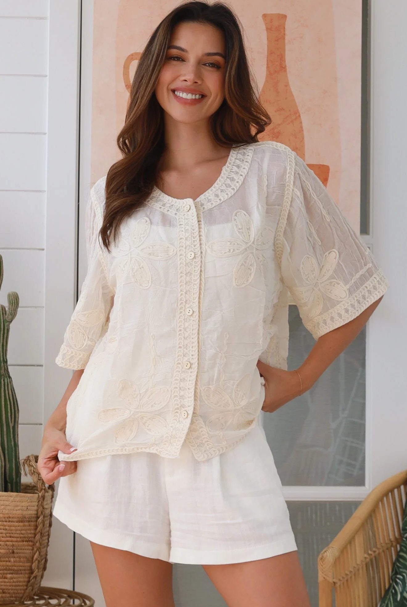 Woman wearing a cream embroidered cotton blouse with artisan trim – Zoe Embroidered Cotton Top Cream.