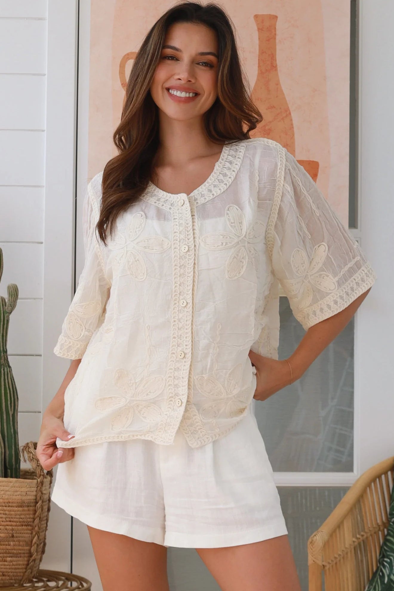 Woman wearing a cream embroidered cotton blouse with artisan trim – Zoe Embroidered Cotton Top Cream.