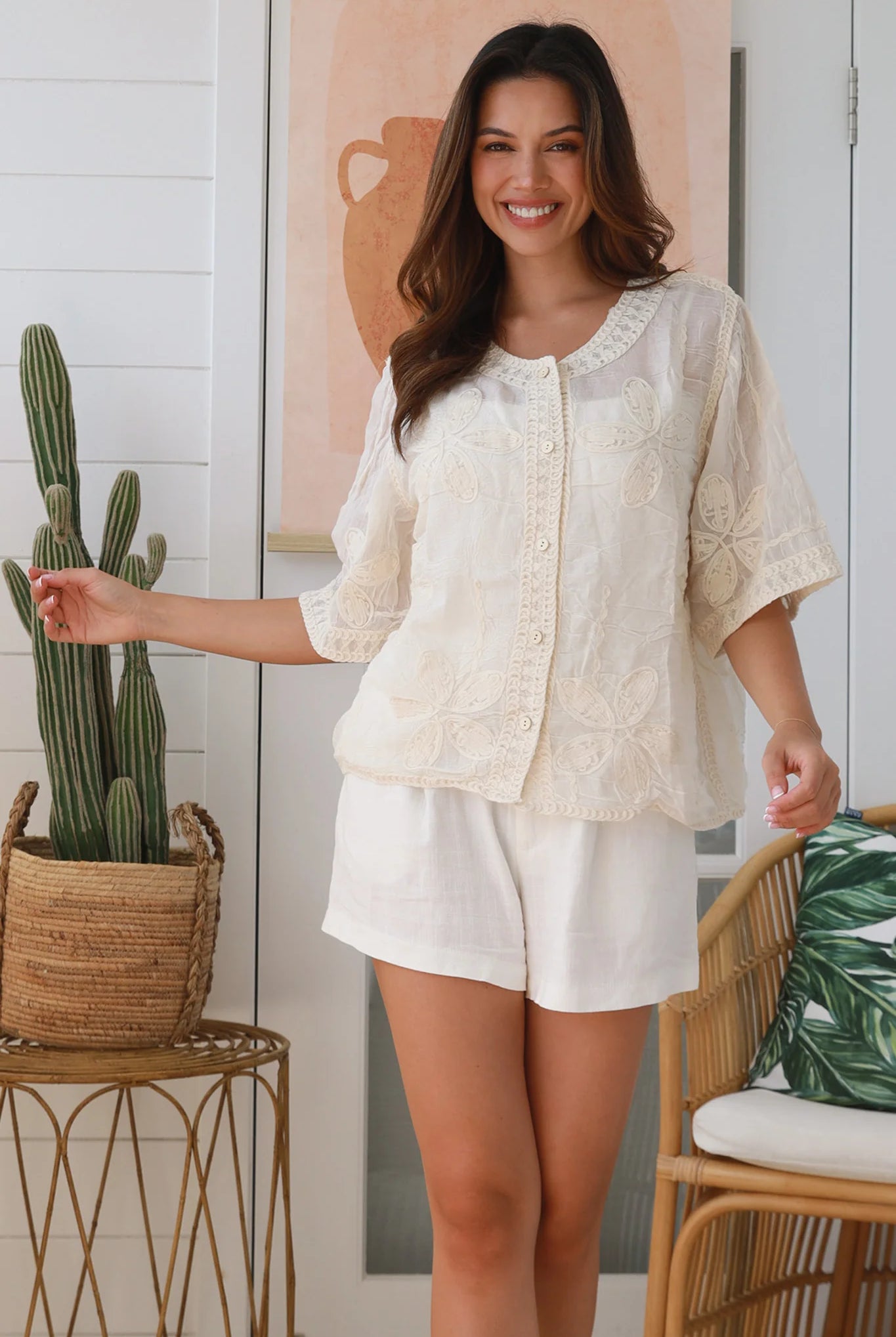 Woman wearing a cream embroidered cotton blouse with artisan trim – Zoe Embroidered Cotton Top Cream.