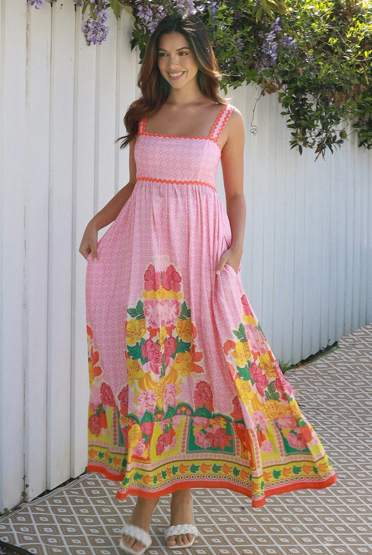 Woman wearing pink floral boho maxi dress with rickrack trim and oversized border hem – Salty Palm