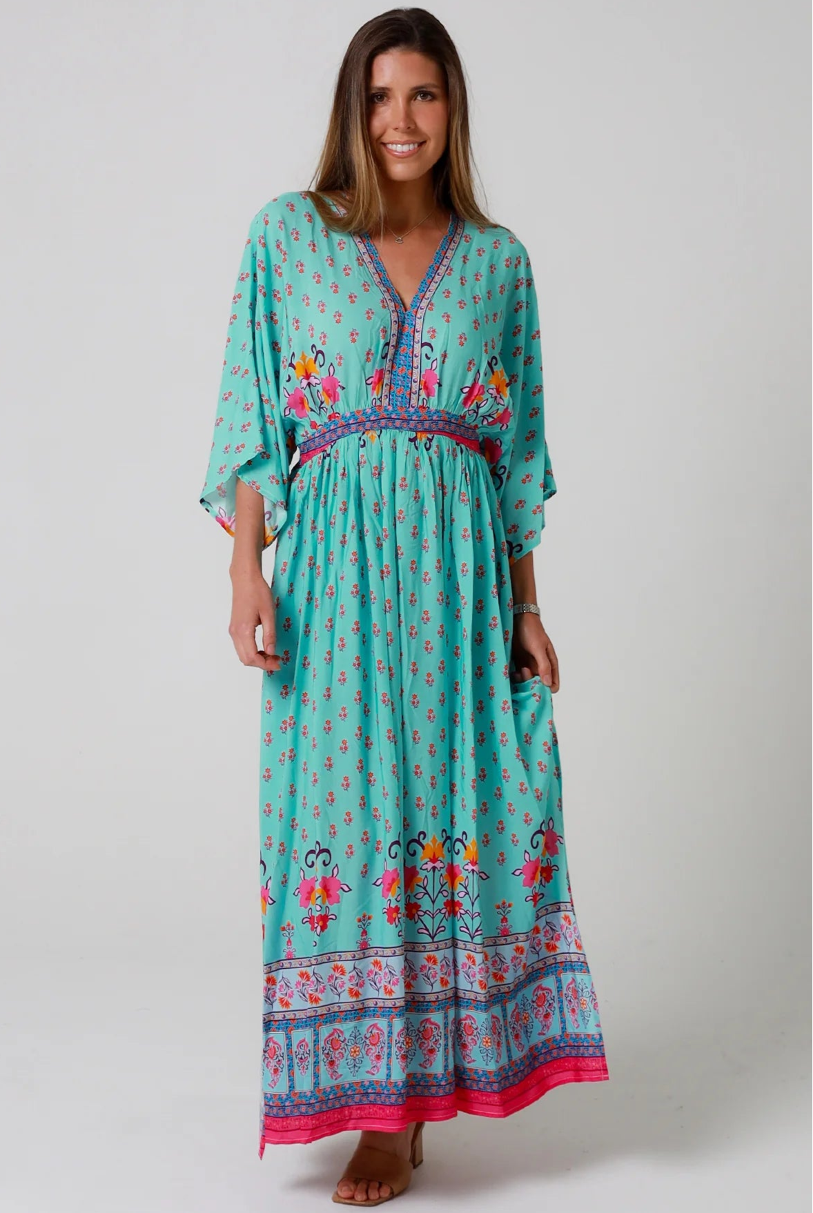 Woman in turquoise floral boho maxi dress with kimono sleeves and border print - Amara Field Maxi Dress Australia.
