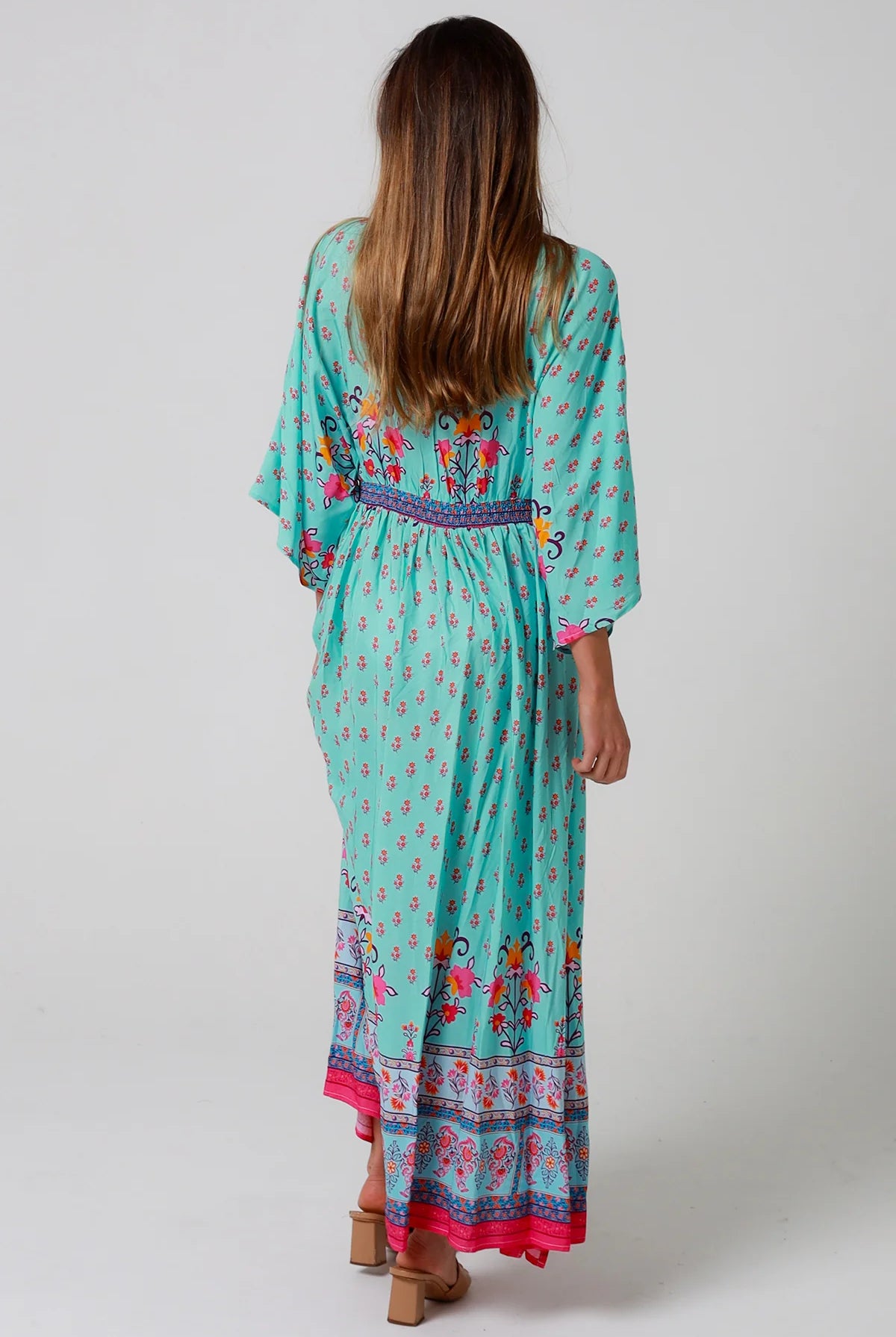 Woman in turquoise floral boho maxi dress with kimono sleeves and border print - Amara Field Maxi Dress Australia.