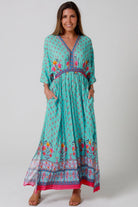 Woman in turquoise floral boho maxi dress with kimono sleeves and border print - Amara Field Maxi Dress Australia.