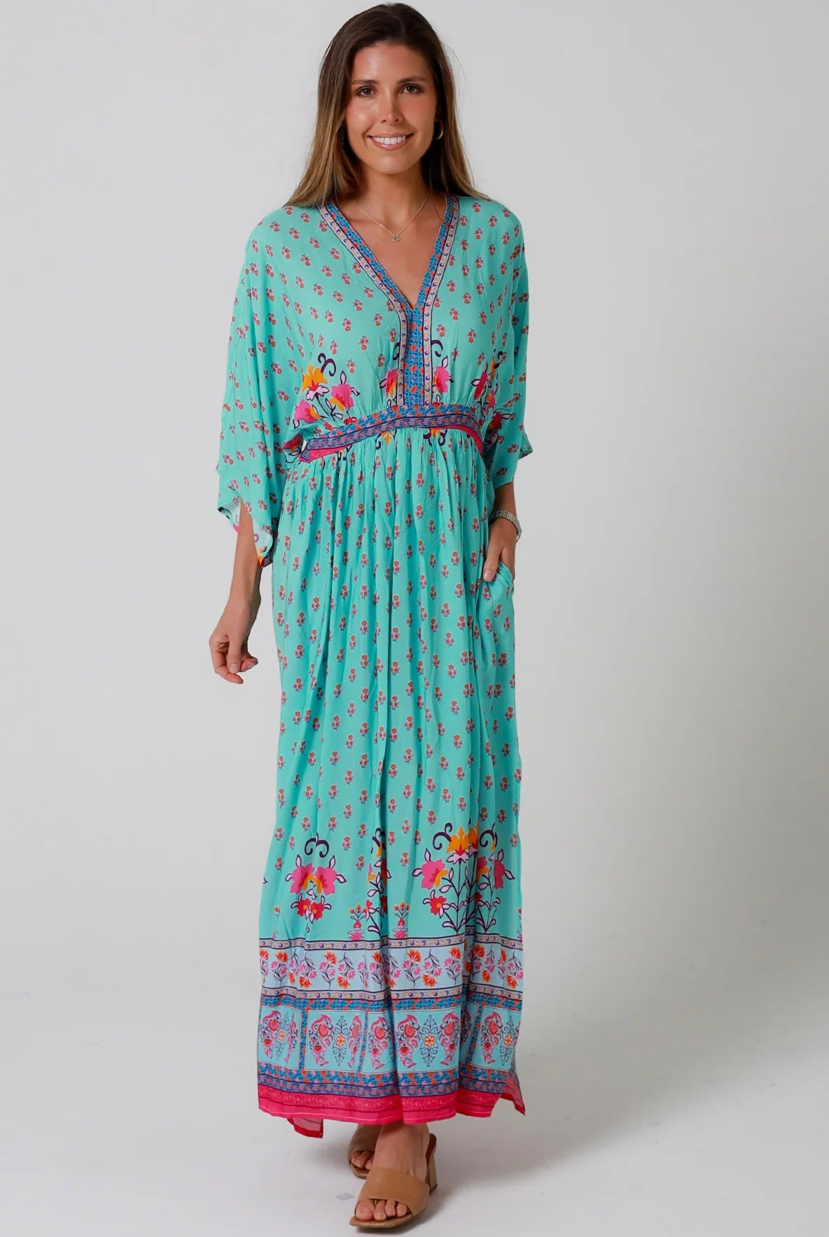 Woman in turquoise floral boho maxi dress with kimono sleeves and border print - Amara Field Maxi Dress Australia.