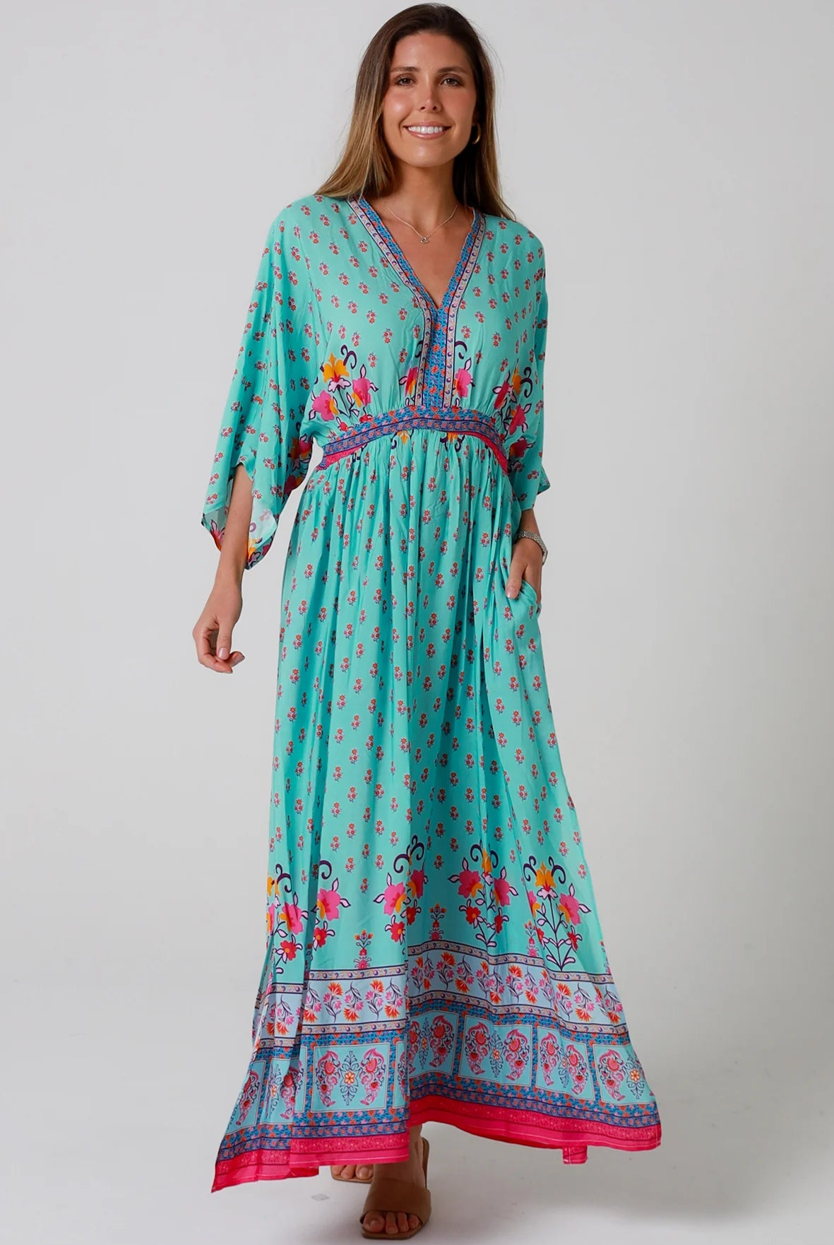 Woman in turquoise floral boho maxi dress with kimono sleeves and border print - Amara Field Maxi Dress Australia.