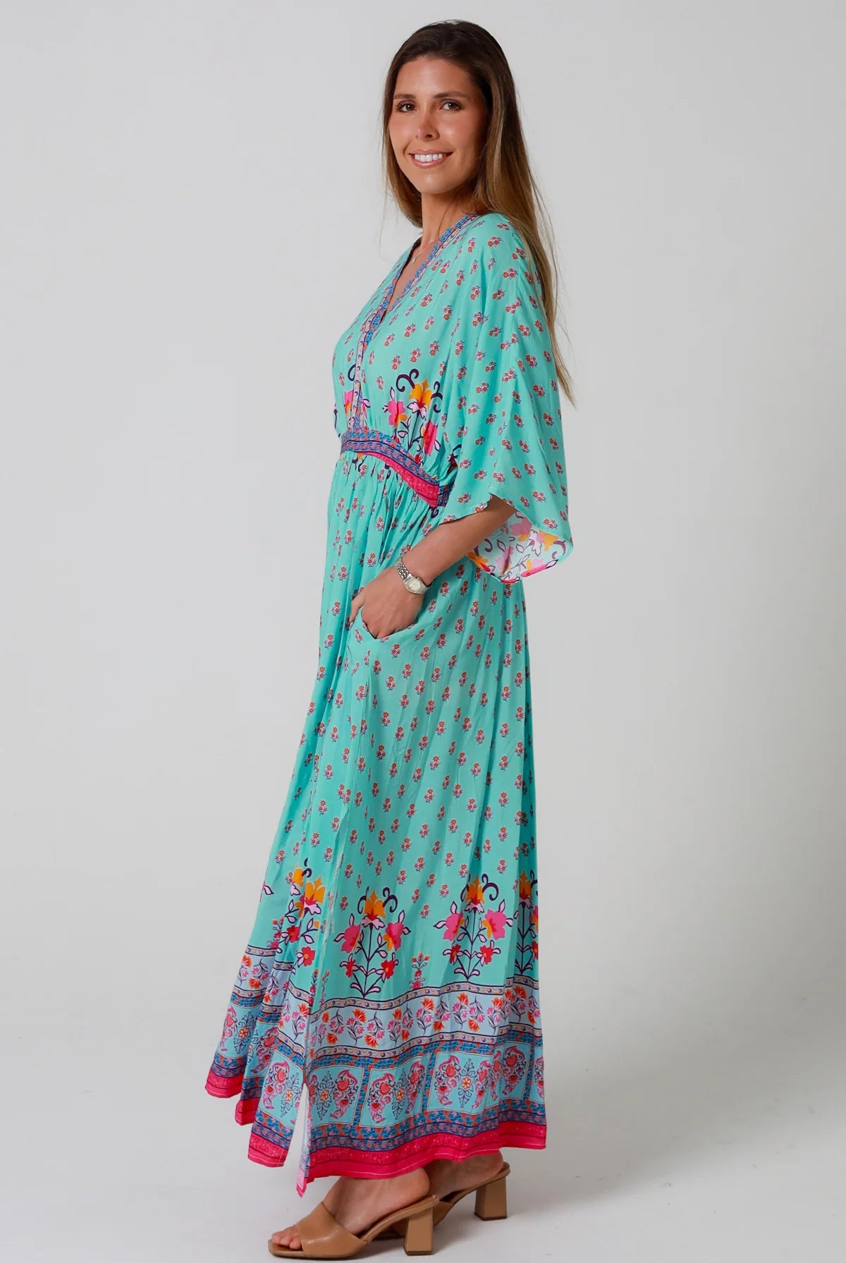 Woman in turquoise floral boho maxi dress with kimono sleeves and border print - Amara Field Maxi Dress Australia.