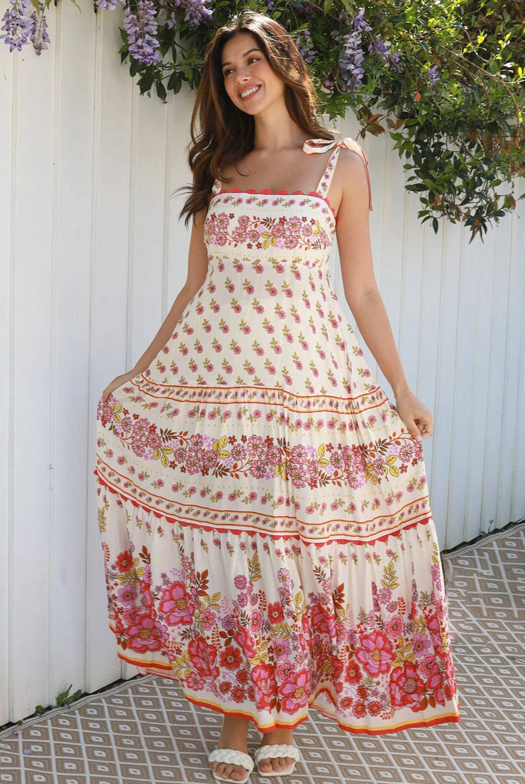 Cream rayon boho maxi dress with blush and rose floral print, tie shoulders, lace trim, and border hemline — Love at First Bloom