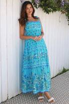 Woman wearing vintage floral boho tie-shoulder maxi dress with border print, rickrack lace and tiered hem – Dreamcatcher Isle of Bloom