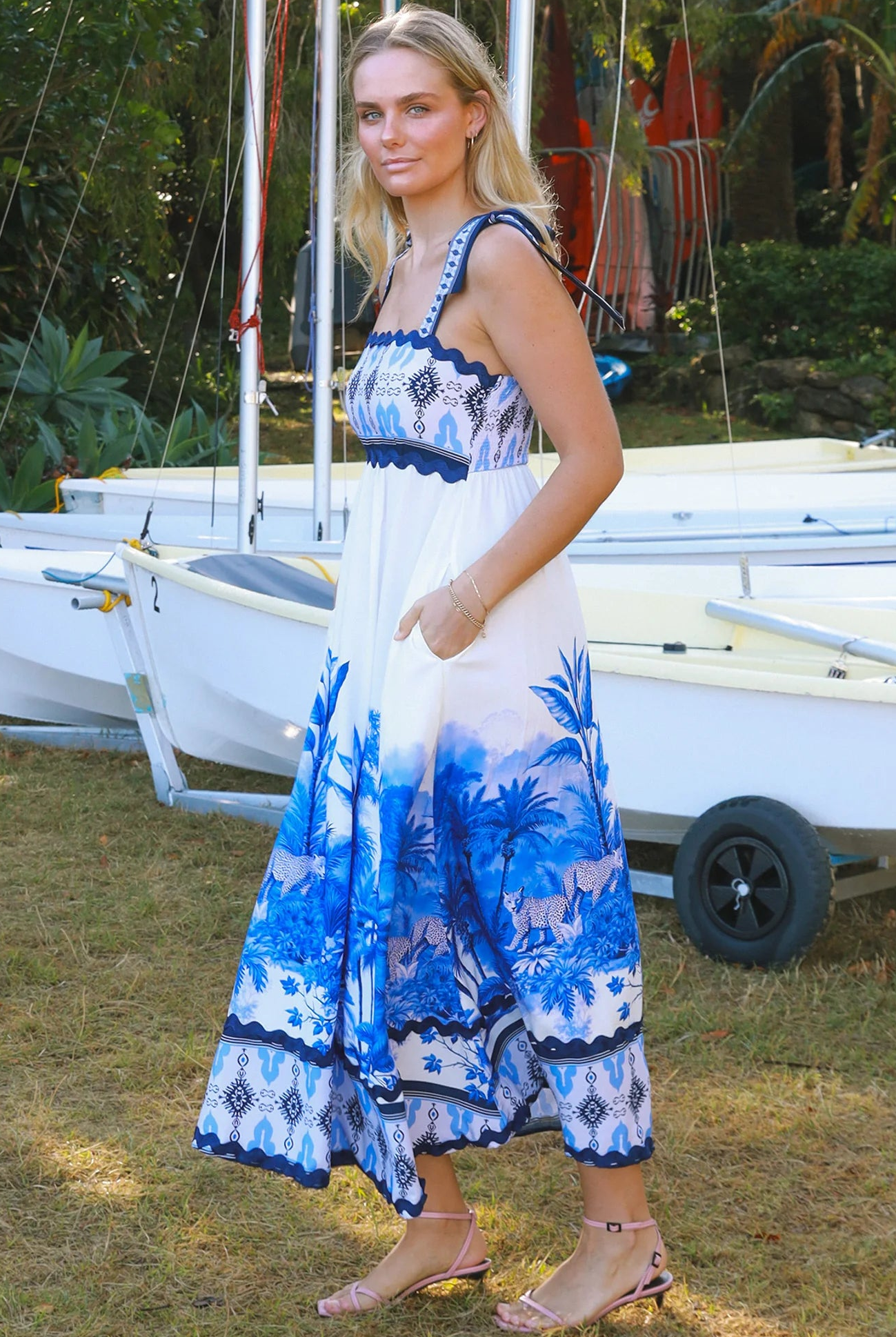 Model wearing blue-white Salty Palm maxi dress with tie straps and border print, light summer aesthetic for warm-weather days.
