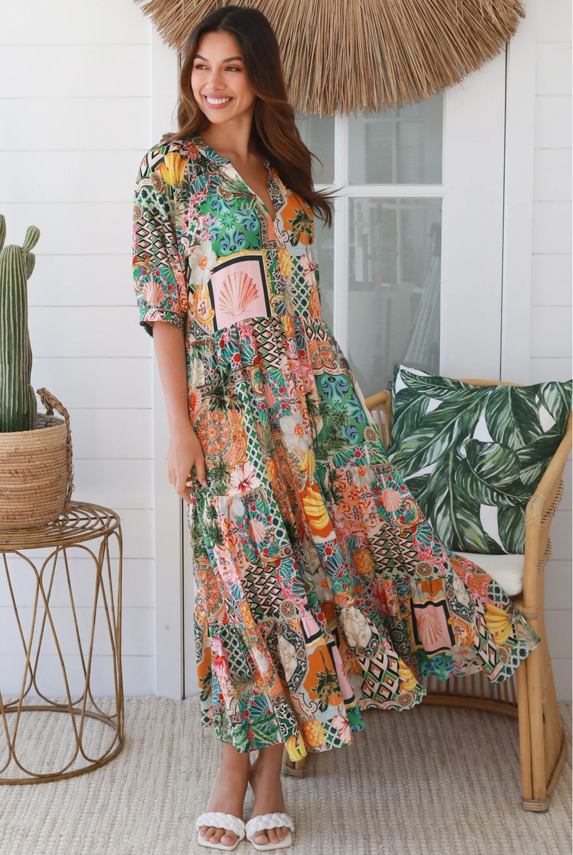 Woman in colourful tropical patchwork rayon midi dress with palms hibiscus and shells - boho chic island style Australia