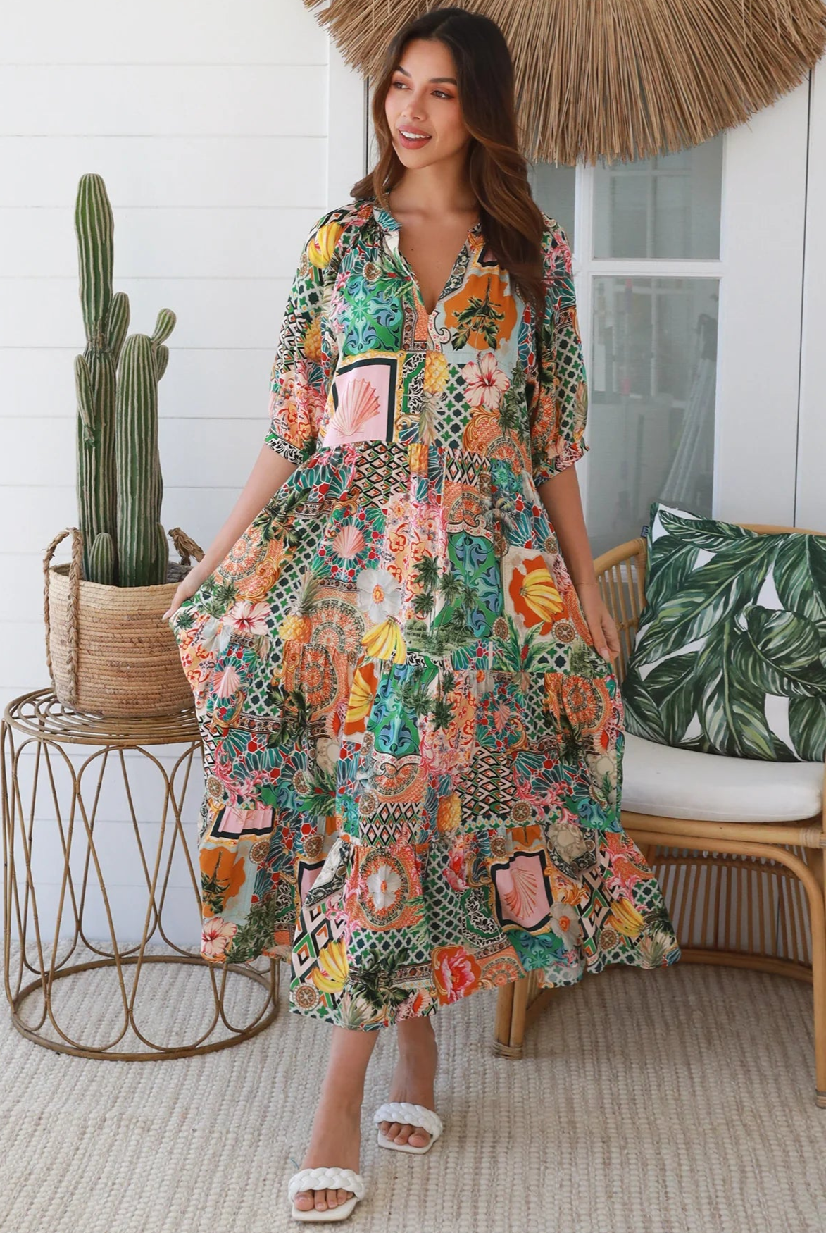 Woman in colourful tropical patchwork rayon midi dress with palms hibiscus and shells - boho chic island style Australia