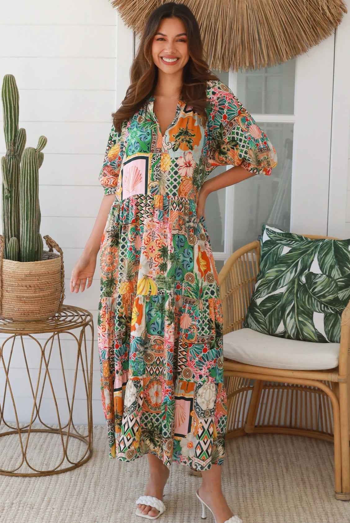 Woman in colourful tropical patchwork rayon midi dress with palms hibiscus and shells - boho chic island style Australia