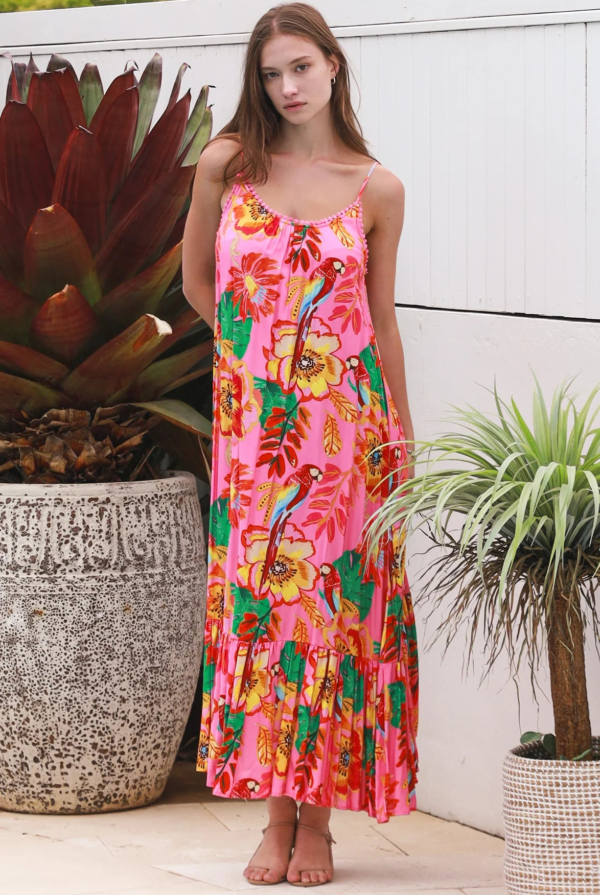 Pink floral slip maxi dress with poppy and parrot print, adjustable shoestring straps and crochet trim neckline
