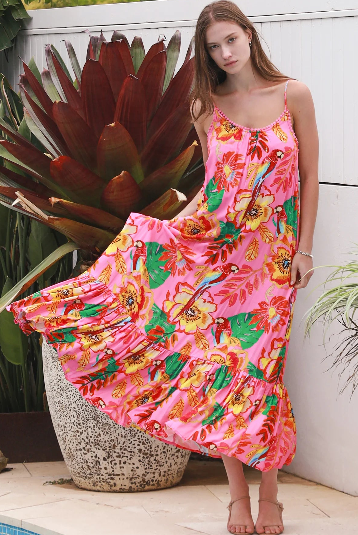 Pink floral slip maxi dress with poppy and parrot print, adjustable shoestring straps and crochet trim neckline