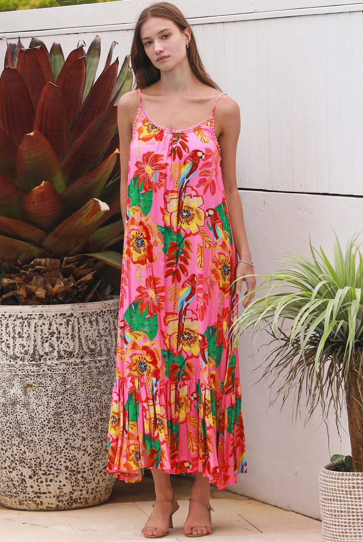 Pink floral slip maxi dress with poppy and parrot print, adjustable shoestring straps and crochet trim neckline