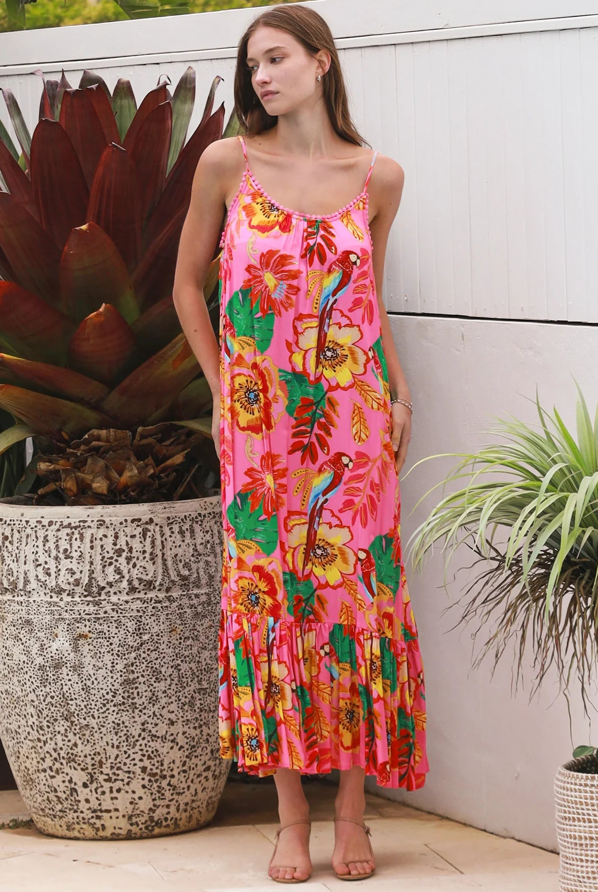 Pink floral slip maxi dress with poppy and parrot print, adjustable shoestring straps and crochet trim neckline