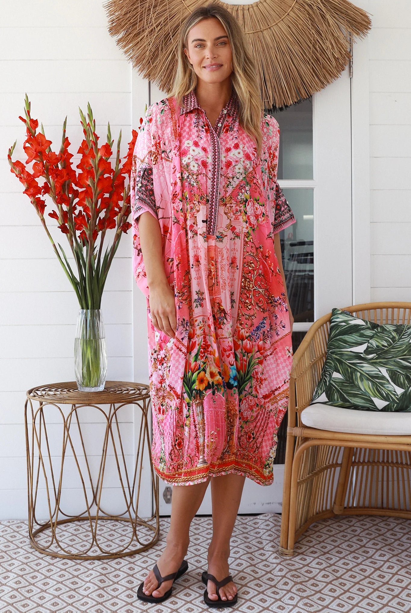 “Woman in pink floral viscose crepe kaftan midi dress with rhinestone buttons by Peacock Feathers – bohemian resort wear Australia”