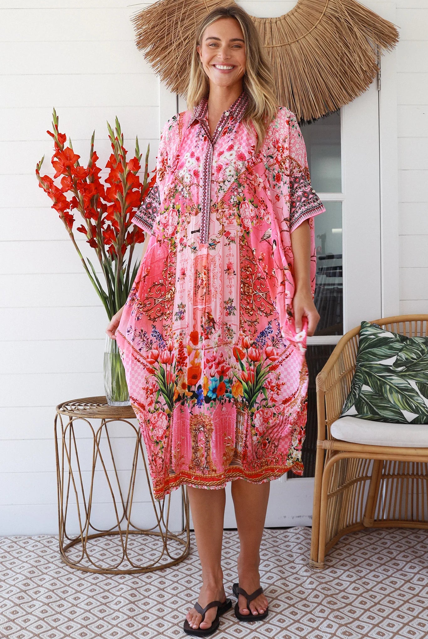 “Woman in pink floral viscose crepe kaftan midi dress with rhinestone buttons by Peacock Feathers – bohemian resort wear Australia”