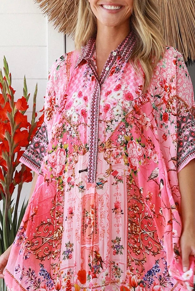 “Woman in pink floral viscose crepe kaftan midi dress with rhinestone buttons by Peacock Feathers – bohemian resort wear Australia”