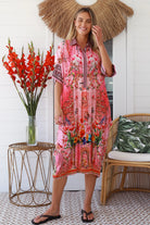 “Woman in pink floral viscose crepe kaftan midi dress with rhinestone buttons by Peacock Feathers – bohemian resort wear Australia”