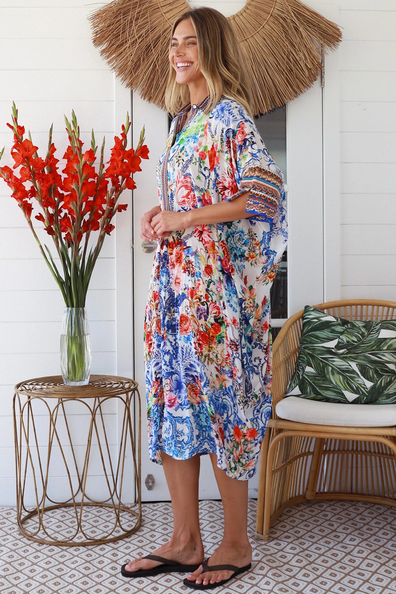 Woman in white viscose crepe kaftan midi dress with coral, jade and cobalt florals by Peacock Feathers Resort Luxe – Boho Dresses Australia