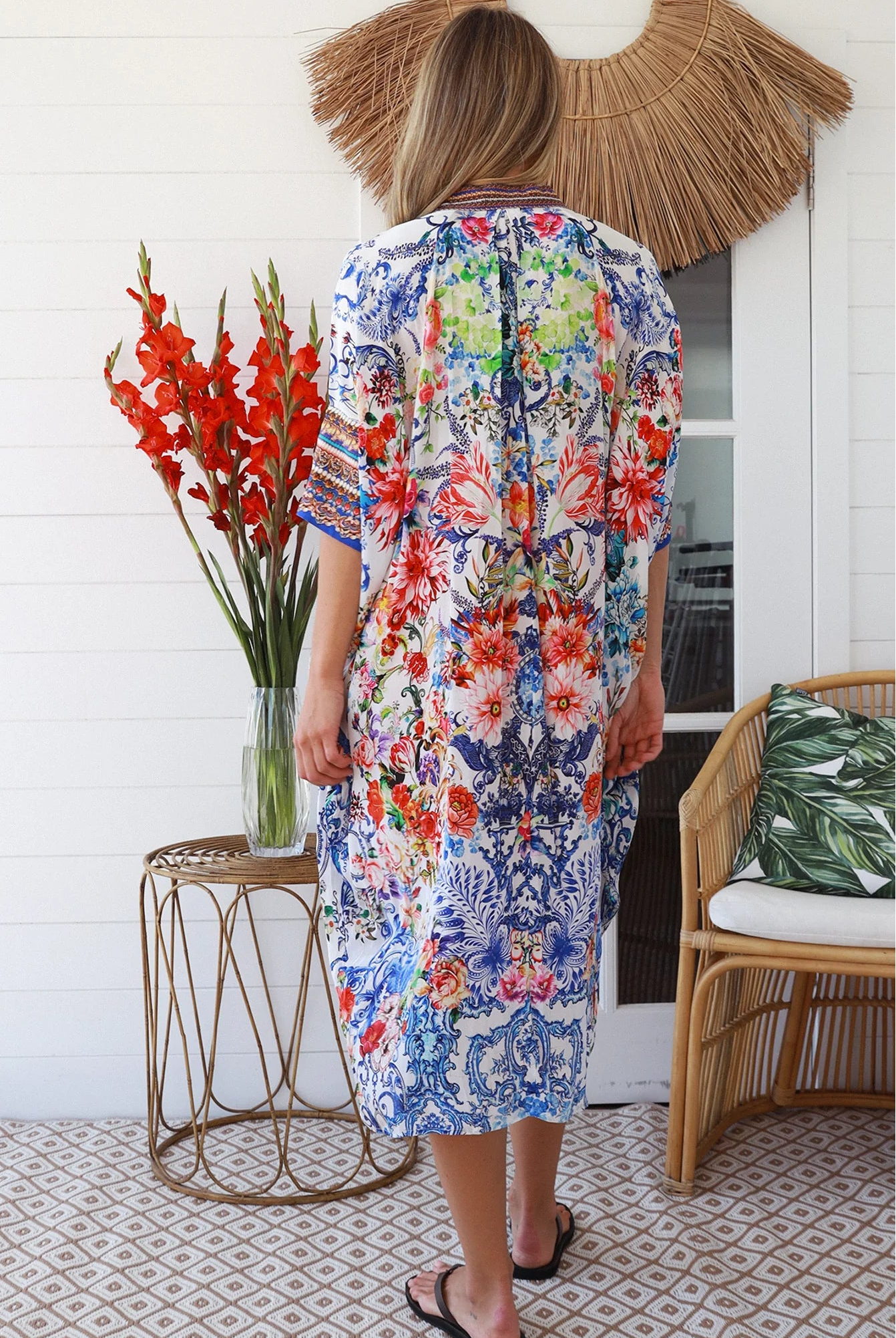 Woman in white viscose crepe kaftan midi dress with coral, jade and cobalt florals by Peacock Feathers Resort Luxe – Boho Dresses Australia